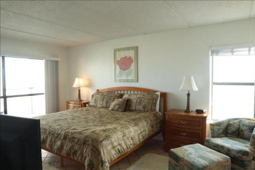 een slaapkamer met een bed en een stoel bij Saida IV Condos S4801 in South Padre Island
