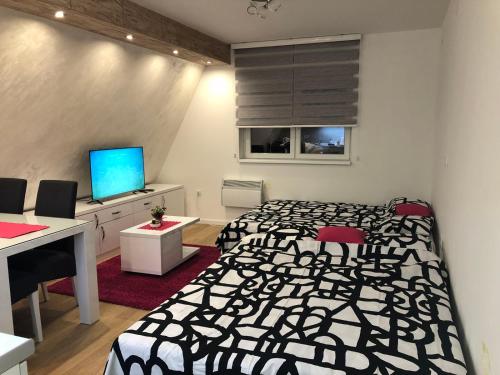Schlafzimmer mit einem schwarzen und weißen Bett und einem Schreibtisch in der Unterkunft Top Kop in Kopaonik