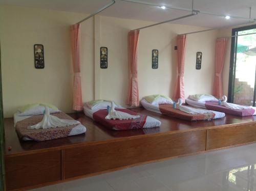 a room with a bunch of pillows on a table at Ruan Mai Naiyang Beach Resort in Nai Yang Beach