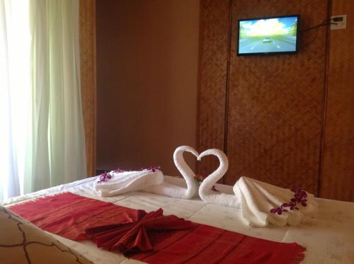 two swans dressed in towels sitting on a bed at Ruan Mai Naiyang Beach Resort in Nai Yang Beach