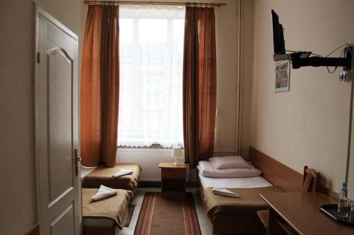 een kamer met 2 bedden en een raam bij Hotel Europejski in Przemyśl