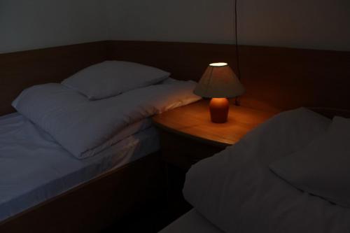 a bedroom with two beds and a lamp on a table at Hotel Europejski in Przemyśl