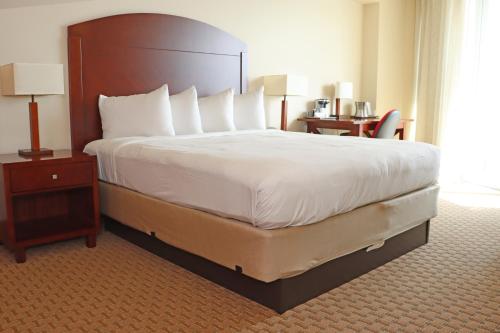 a hotel room with a large bed and a chair at Costa Bahia Hotel Paseo Caribe in San Juan