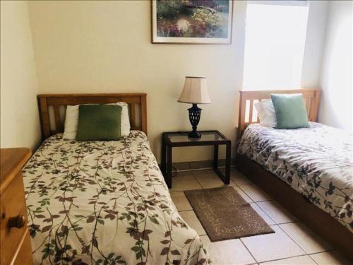 a bedroom with two beds and a table with a lamp at Suntide I Condos W102 in South Padre Island