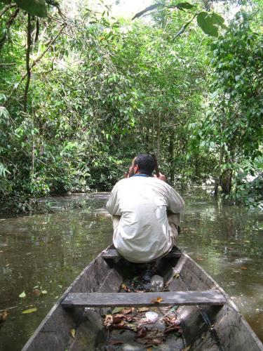 a man riding in a boat in the water at Reserva Natural Heliconia Amazonas in Leticia