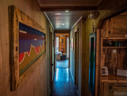 a hallway of a house with a painting on the wall at Puma House in Puerto Natales