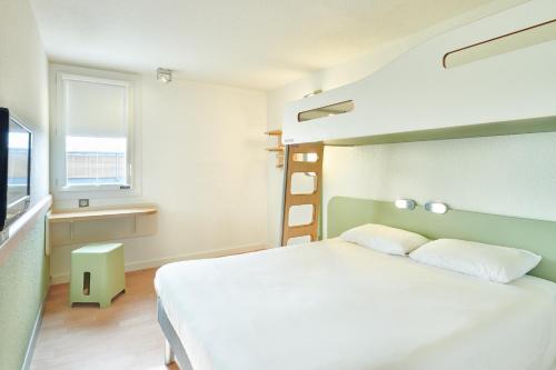 a bedroom with a large white bed and a window at ibis budget Saint Paul Les Dax in Saint-Paul-lès-Dax