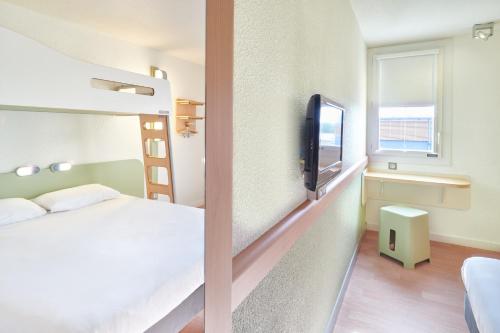 a hotel room with a bed and a tv at ibis budget Saint Paul Les Dax in Saint-Paul-lès-Dax