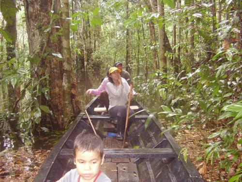 a group of people in a boat in the jungle at Reserva Natural Heliconia Amazonas in Leticia