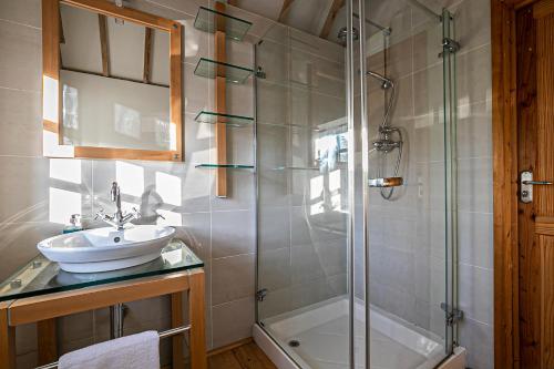 a bathroom with a sink and a glass shower at Pages Hotel and Guesthouse in Harlow