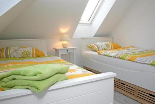 a bedroom with two beds with green blankets on them at Zuhause Woanders - Kuhtrade in Wildeshausen