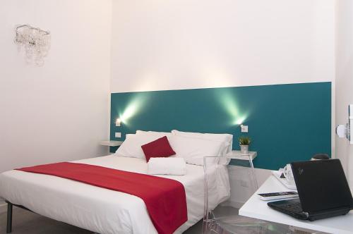 a bedroom with a bed and a laptop on a desk at Modica Old Town Rooms in Modica