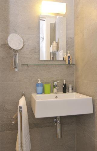 a bathroom with a white sink and a mirror at Modica Old Town Rooms in Modica