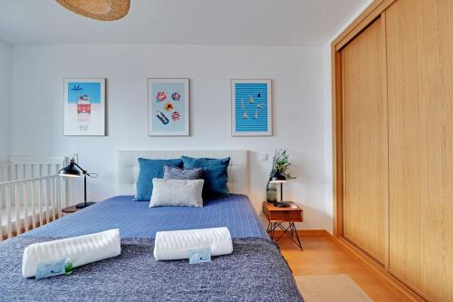 a bedroom with a blue bed with two pillows on it at Tavira Formosa Bay by Homing in Cabanas de Tavira