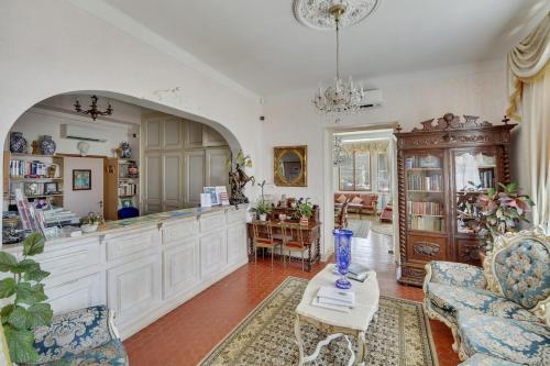 une cuisine avec des placards blancs et un vase sur une table dans l'établissement Le Château de Mei Lese, à La Croix-Valmer