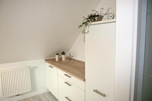 a kitchen with white cabinets and a wooden counter at Zuhause Woanders - Kuhtrade in Wildeshausen