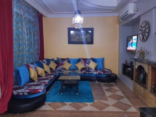 ein Wohnzimmer mit einem blauen Sofa und einem Tisch in der Unterkunft Villa Fatima in Meknès