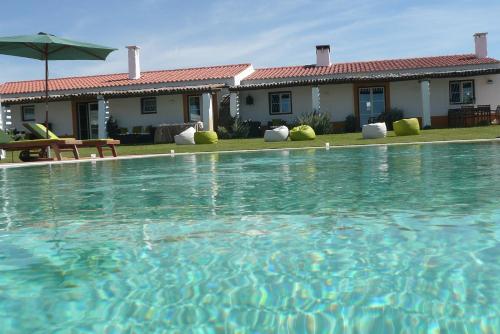 a large swimming pool in front of a house at SeteQuintas in Zambujeira do Mar