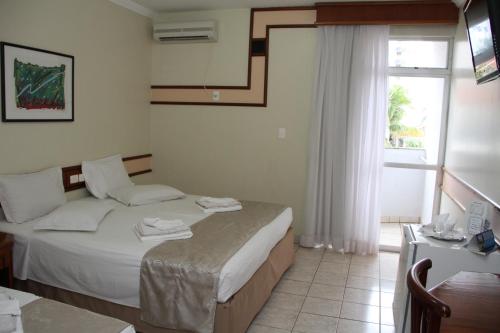 Habitación de hotel con cama y ventana en Hotel Taiyo, en Caldas Novas