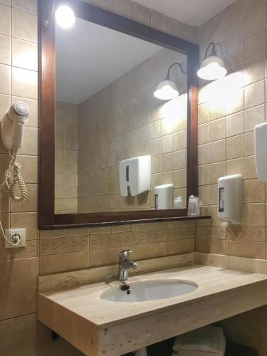 a bathroom with a sink and a large mirror at Hotel Fonda Merce in Llivia