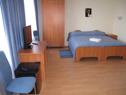 a bedroom with a bed and a desk and a television at Hotel on Kazanskoy in Rybinsk
