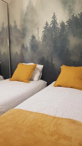 two beds with yellow pillows in a bedroom at JH2 domek M&M Apartments in Altanka