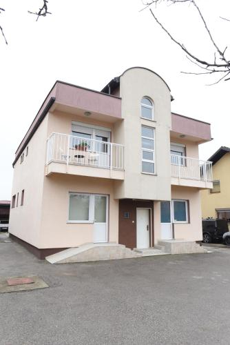 a large white building with a balcony at Bingo Apartments in Banja Luka