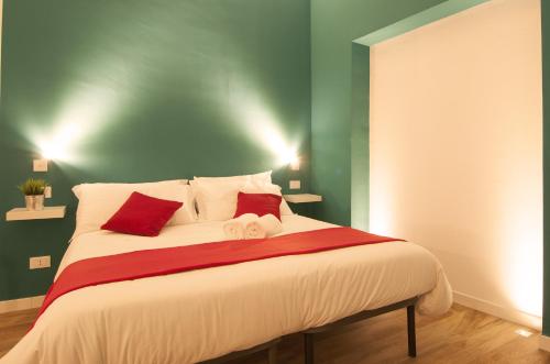 a bedroom with a large bed with red and green walls at Modica Old Town Rooms in Modica