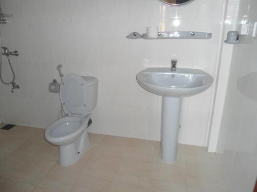 a bathroom with a toilet and a sink at Main Reef Guest House in Hikkaduwa