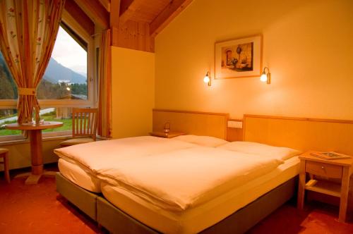 a bedroom with a bed and a large window at Adrian in Sankt Anton am Arlberg
