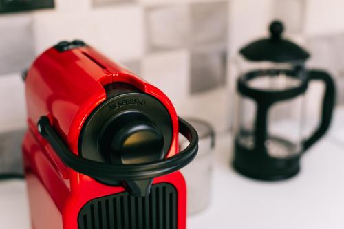 a red appliance sitting on a counter next to a tea kettle at Volos Suites Center in Volos