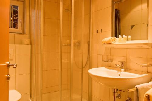 y baño con ducha, lavamanos y ducha. en Adrian en Sankt Anton am Arlberg