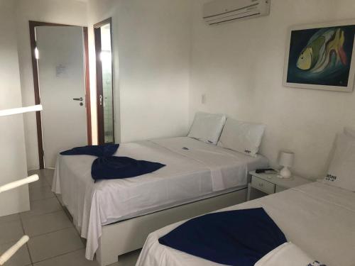 a hotel room with two beds with blue pillows at Nannai Beira Mar Porto de Galinhas 307 in Porto De Galinhas