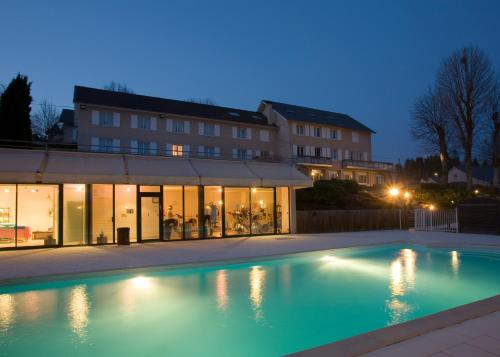 a swimming pool in front of a building at night at Bel Horizon in Le Chambon-sur-Lignon