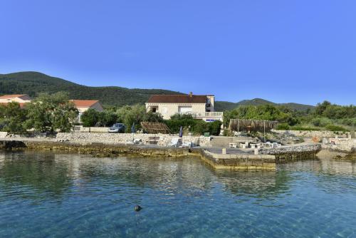 a body of water with a house in the background at Apartments MAK in Račišće