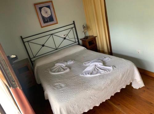 Un dormitorio con una cama con toallas blancas. en APARTAMENTOS MARIAJE, en Barro de Llanes