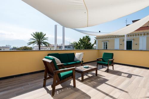 a balcony with a couch and two chairs and a table at Dream House Pompei in Pompei