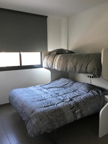 two beds in a small room with a window at Casa de la vida La Zenia in Playas de Orihuela