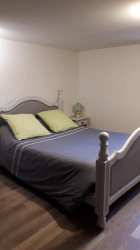 um quarto com uma cama grande e almofadas amarelas em T1 Dans Maison Au Calme em Réalmont