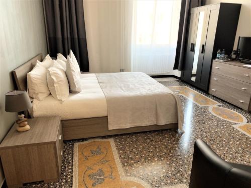 een slaapkamer met een bed, een tafel en een dressoir bij BASILICO Genova in Genua