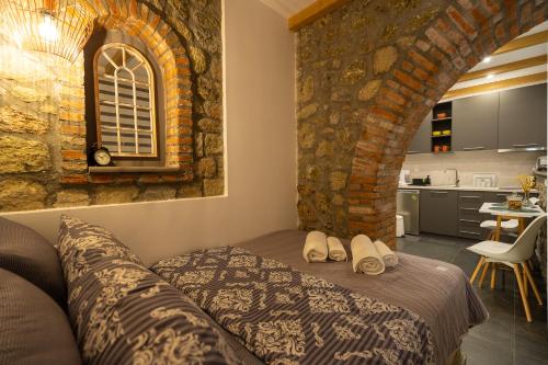 a bedroom with a bed and a stone wall at SaltHouse #3 in Kalabaka