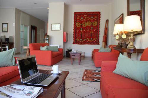 a living room with red couches and a laptop on a table at Altos De Balcarce Hotel in Salta