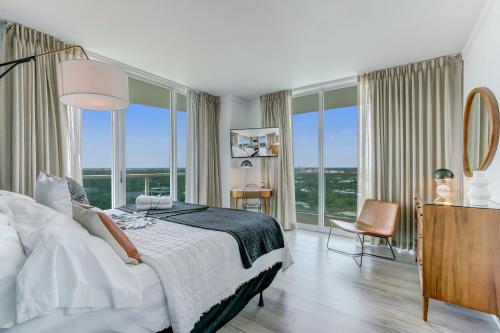 - une chambre avec un grand lit et de grandes fenêtres dans l'établissement iCoconutGrove - Luxurious Vacation Rentals in Coconut Grove, à Miami