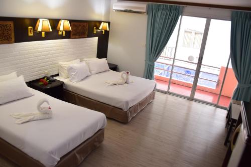 a hotel room with two beds with swans on them at Wan Wan Place in Ao Nang Beach