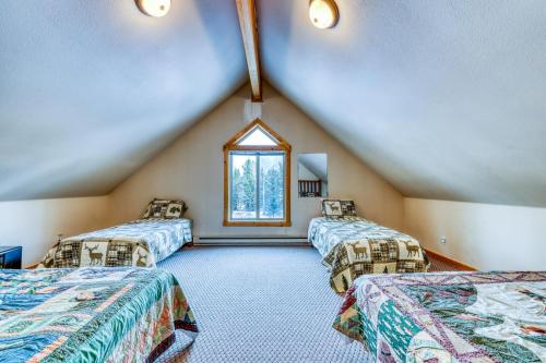 a attic room with three beds and a window at Big Timber in McCall