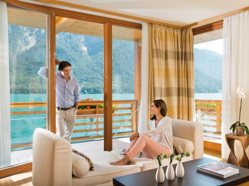 a man and a woman sitting on a couch in a living room at aja Fürstenhaus am Achensee in Pertisau