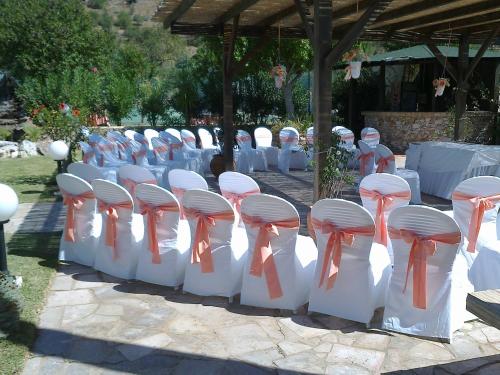 a row of white chairs with orange ties on them at Alte Hotel in Alte