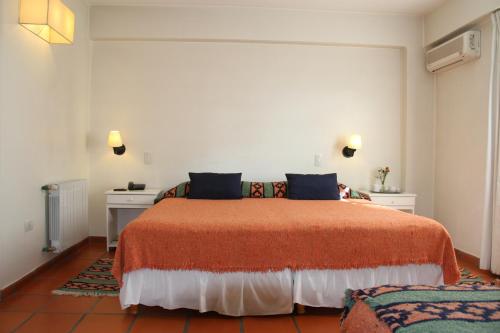 a bedroom with a large bed and a desk at Altos De Balcarce Hotel in Salta