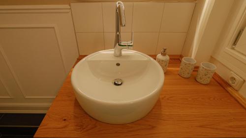 a white sink sitting on top of a wooden floor at Rosenhof-Lodge in Hanerau-Hademarschen