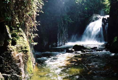 a waterfall in the middle of a river at Maua Brasil Hotelaria in Visconde De Maua